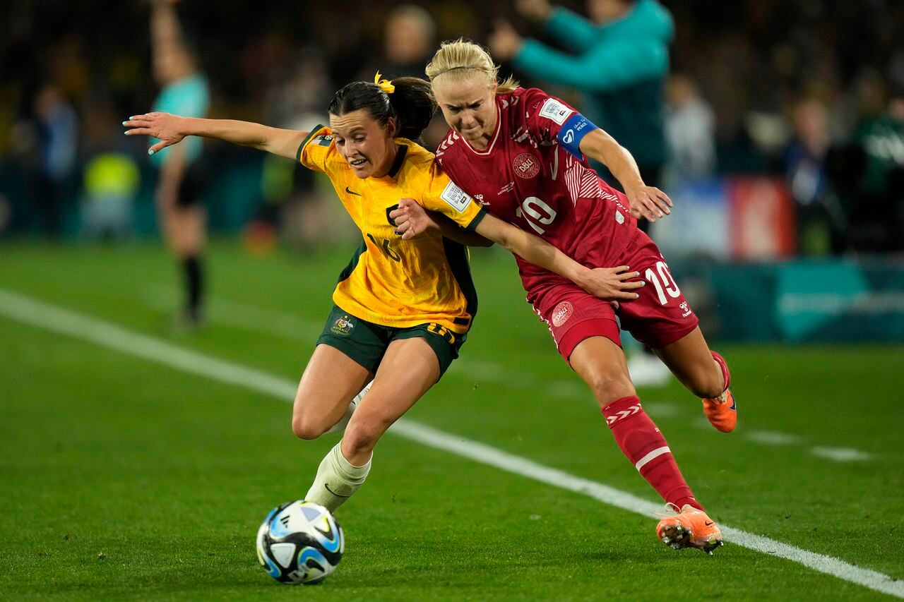 Hayley Raso de Australia, a la izquierda, y Pernille Harder de Dinamarca desafían el balón durante el partido de fútbol de octavos de final de la Copa Mundial Femenina entre Australia y Dinamarca en el Estadio Australia en Sídney, Australia, el lunes 7 de agosto de 2023. (Foto AP/Rick Rycroft )