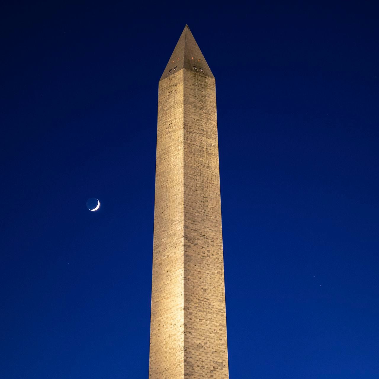 La Luna (izquierda), Saturno (derecha superior) y Júpiter (derecha inferior), tal como se ven después de la puesta del sol con el Monumento a Washington,