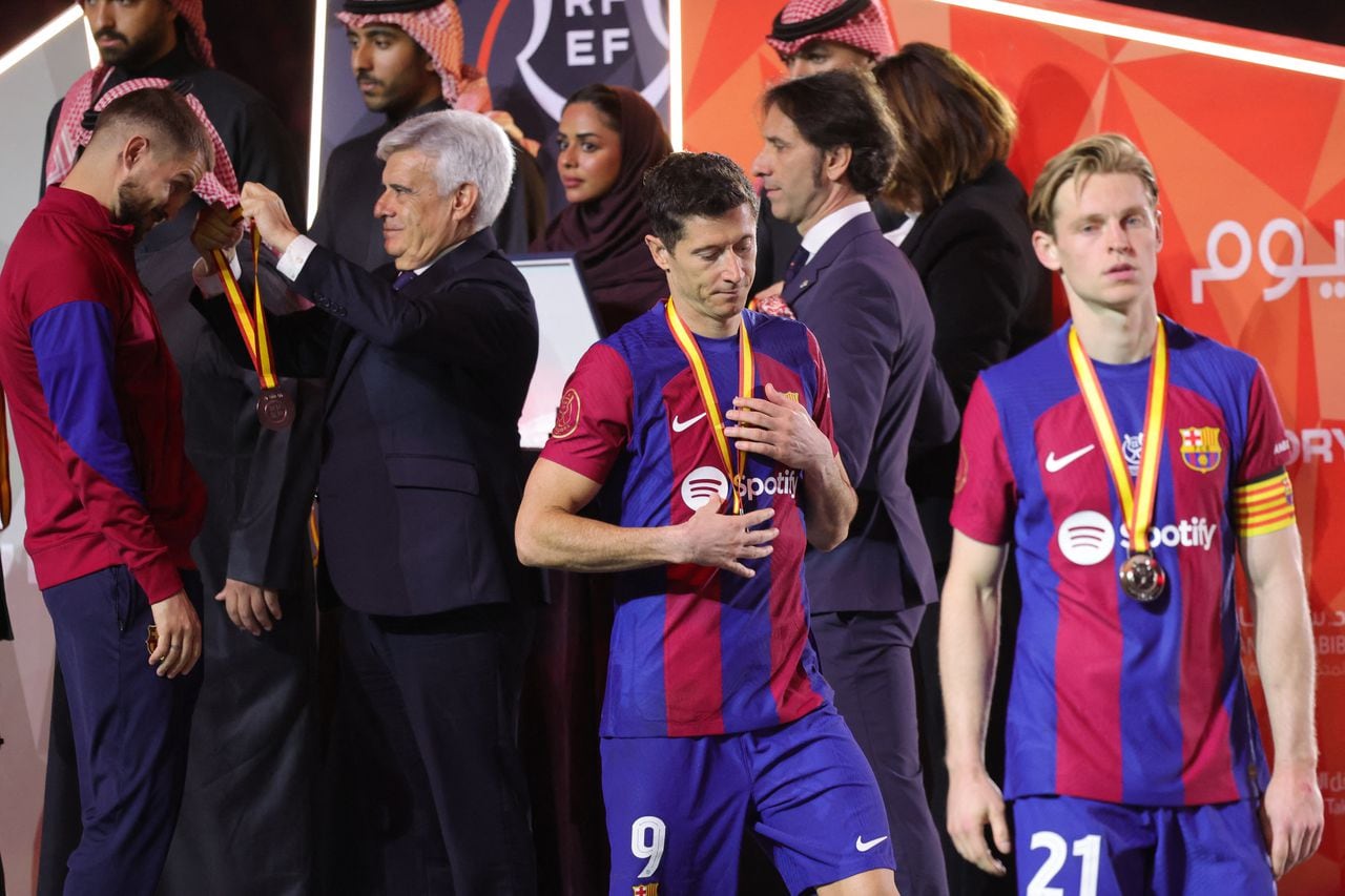 Barcelona's Dutch midfielder #21 Frenkie de Jong and Barcelona's Polish forward #09 Robert Lewandowski walk during the medal ceremony after the Spanish Super Cup final football match between Real Madrid and Barcelona at the Al-Awwal Park Stadium in Riyadh, on January 14, 2024. (Photo by Giuseppe CACACE / AFP)