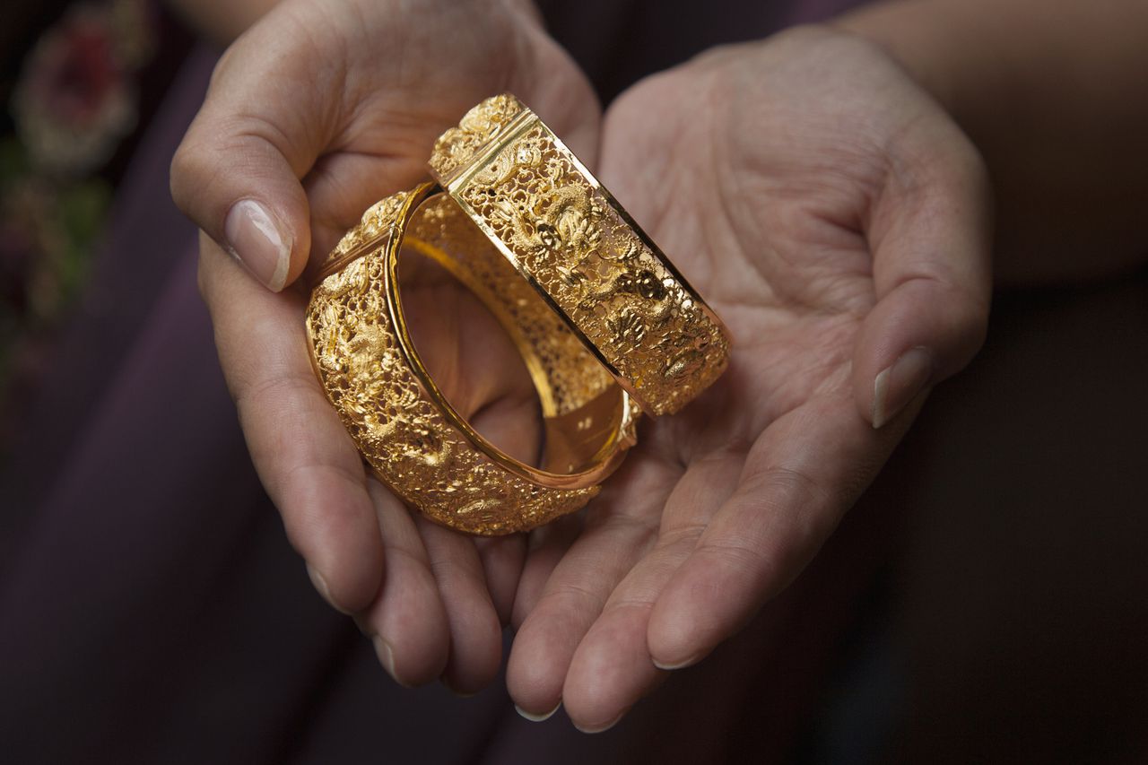 Solid gold bracelets are given as traditional wedding gifts to a Chinese couple. Chinese brides often change dresses during the wedding day mixing traditional Chinese dresses with Western gowns.