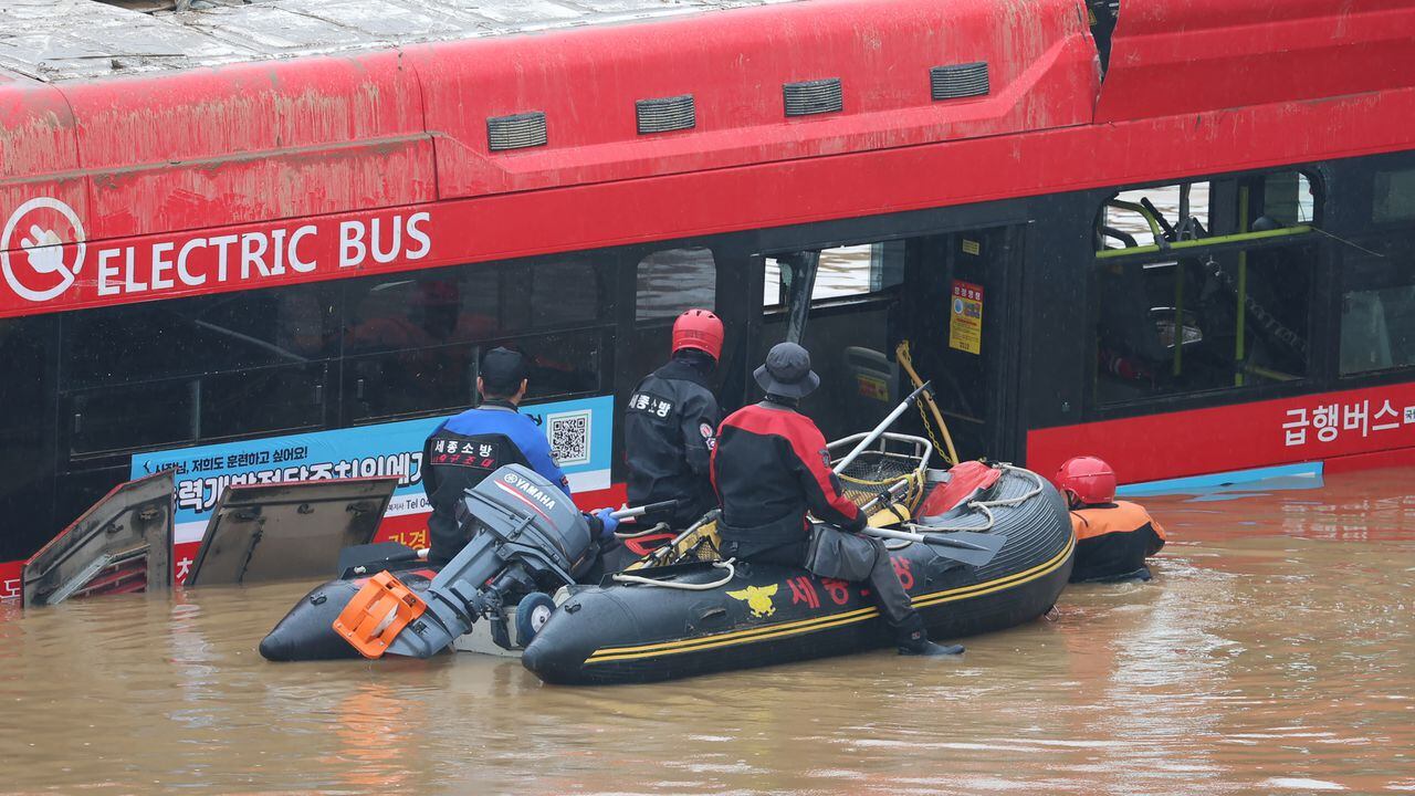 Los rescatistas de Corea del Sur buscan personas desaparecidas cerca de un autobús a lo largo de una carretera inundada que conduce a un túnel subterráneo donde unos 15 automóviles quedaron atrapados en las aguas de la inundación después de las fuertes lluvias en Cheongju el 16 de julio de 2023.