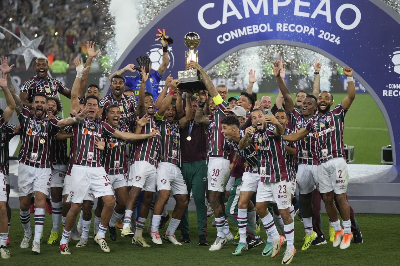 Los jugadores del Fluminense de Brasil sostienen el trofeo mientras celebran después de ganar la final de la Recopa Sudamericana contra la Liga Deportiva Universitaria de Ecuador en el estadio Maracaná de Río de Janeiro, Brasil, el jueves 29 de febrero de 2024. (Foto AP/Silvia Izquierdo)