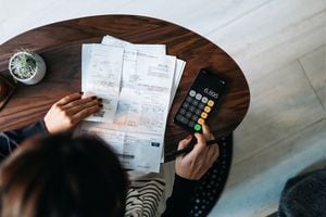 Foto de referencia de facturas en medio de una persona haciendo cálculos