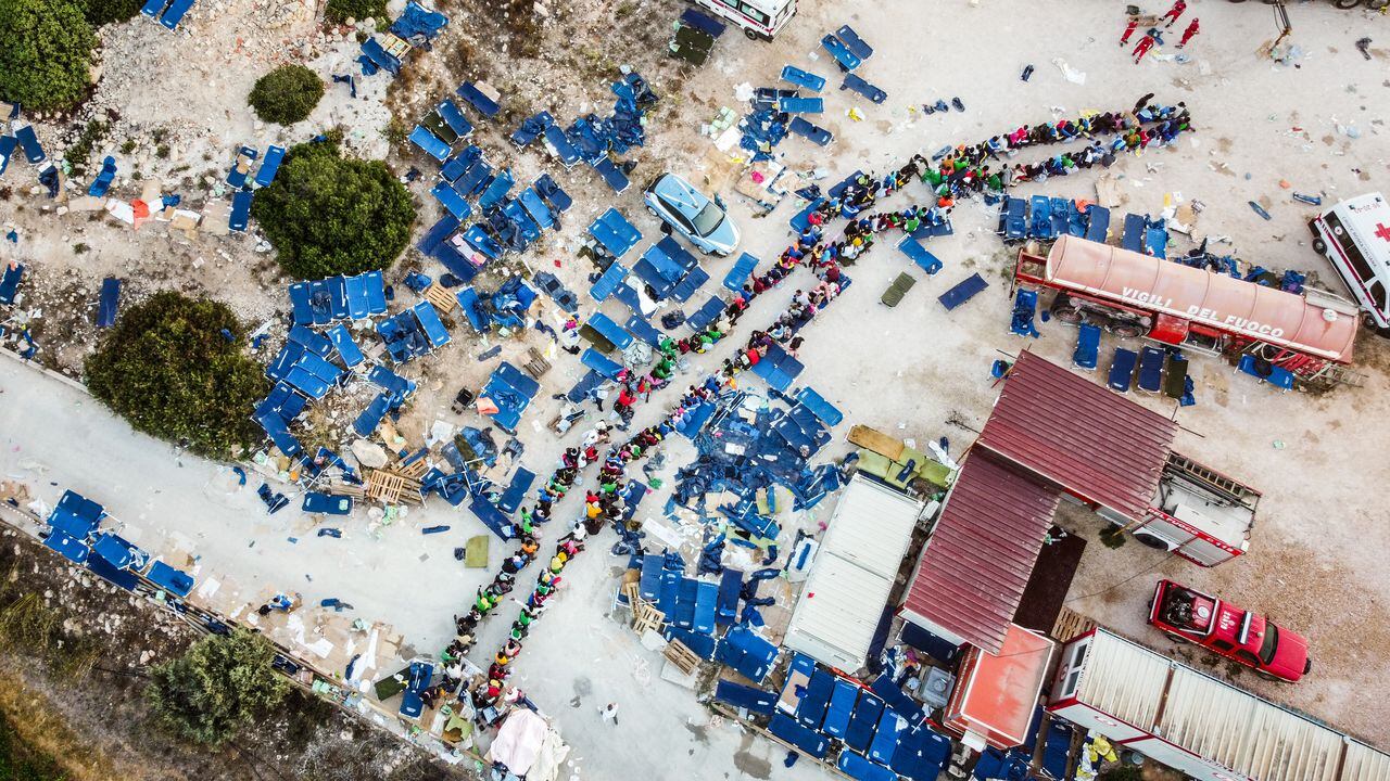 Esta fotografía aérea tomada el 14 de septiembre de 2023 muestra a los migrantes reunidos frente al centro operativo llamado "Hotspot" en la isla italiana de Lampedusa.