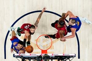 El escolta de los Denver Nuggets, Jamal Murray, abajo a la izquierda, dispara mientras lo defiende el alero del Miami Heat, Caleb Martin (16), durante la primera mitad del Juego 1 de las Finales de baloncesto de la NBA, el jueves 1 de junio de 2023, en Denver. 