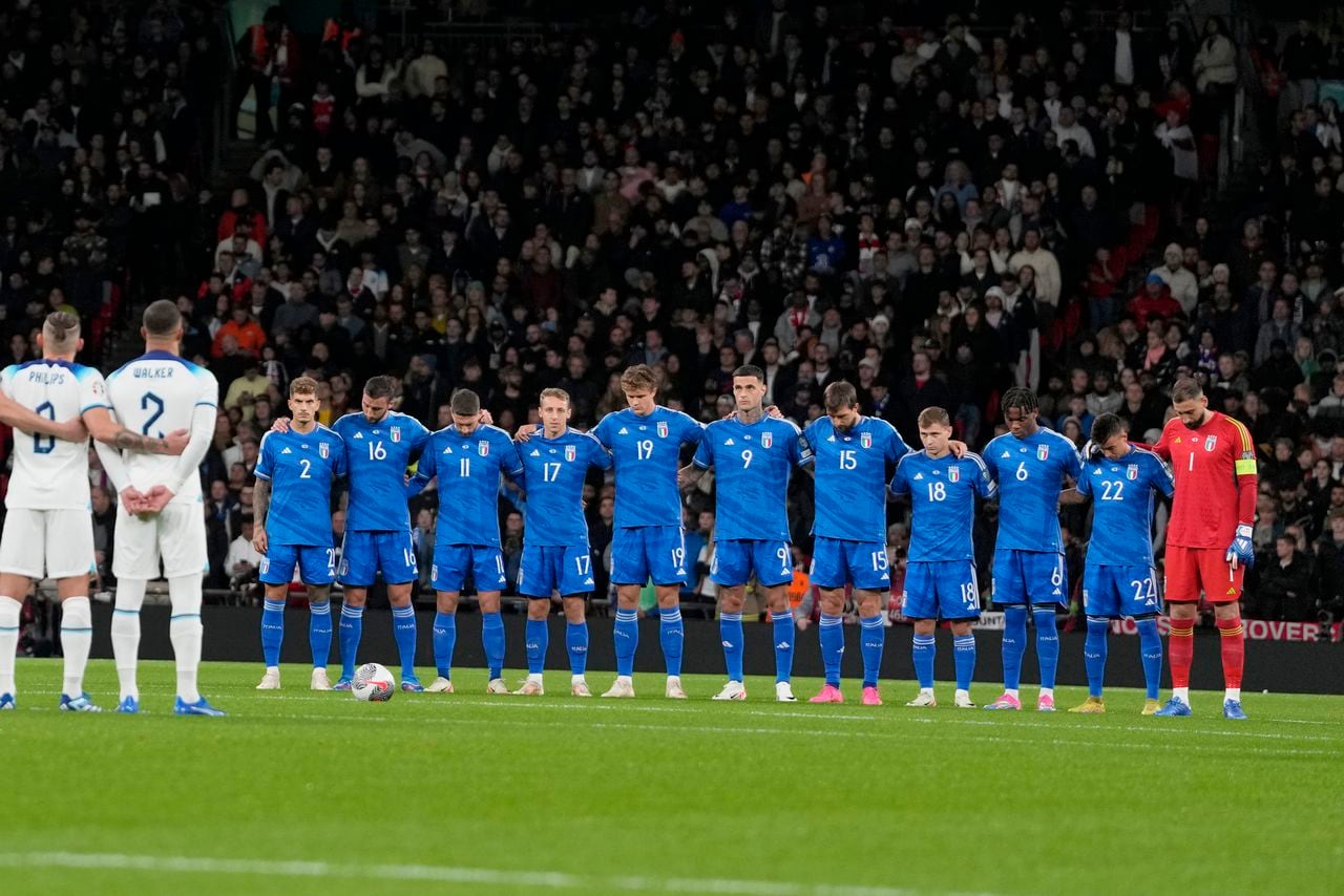 Los jugadores de Italia (derecha) e Inglaterra guardan un momento de silencio por las víctimas de los recientes ataques en Bélgica e Israel antes del partido de fútbol del grupo C de clasificación para la Eurocopa 2024 entre Inglaterra e Italia en el estadio de Wembley en Londres, el martes 17 de octubre de 2023. (Foto AP/Kirsty Wigglesworth)