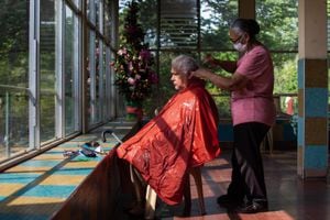 Alba Inés García, de 65 años, le hace un corte de cabello a su esposo, Pablo Máximo Cabrera, de 79, en el segundo piso del geriátrico. Además de residentes, ambos son predicadores católicos en la institución desde hace cinco años.