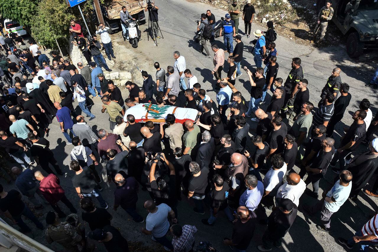 Los dolientes llevan el ataúd cubierto con la bandera del video periodista libanés de Reuters Issam Abdallah, asesinado el 13 de octubre por bombardeos israelíes en la aldea fronteriza de Alma al-Shaab con Israel mientras cubría bombardeos transfronterizos, durante su funeral en la aldea de El-Khiam el 14 de octubre. , 2023. Abdallah fue asesinado el 13 de octubre y otras seis personas de AFP, Reuters y Al Jazeera resultaron heridas mientras trabajaban en el sur del Líbano, dijeron las tres organizaciones de noticias. (Photo by Fadel ITANI / AFP)