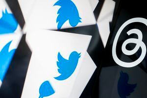 Esta ilustración fotográfica creada en Washington, DC, el 5 de julio de 2023, muestra el logotipo de Twitter reflejado cerca del logotipo de Threads, una aplicación de Instagram. (Photo by Stefani Reynolds / AFP)