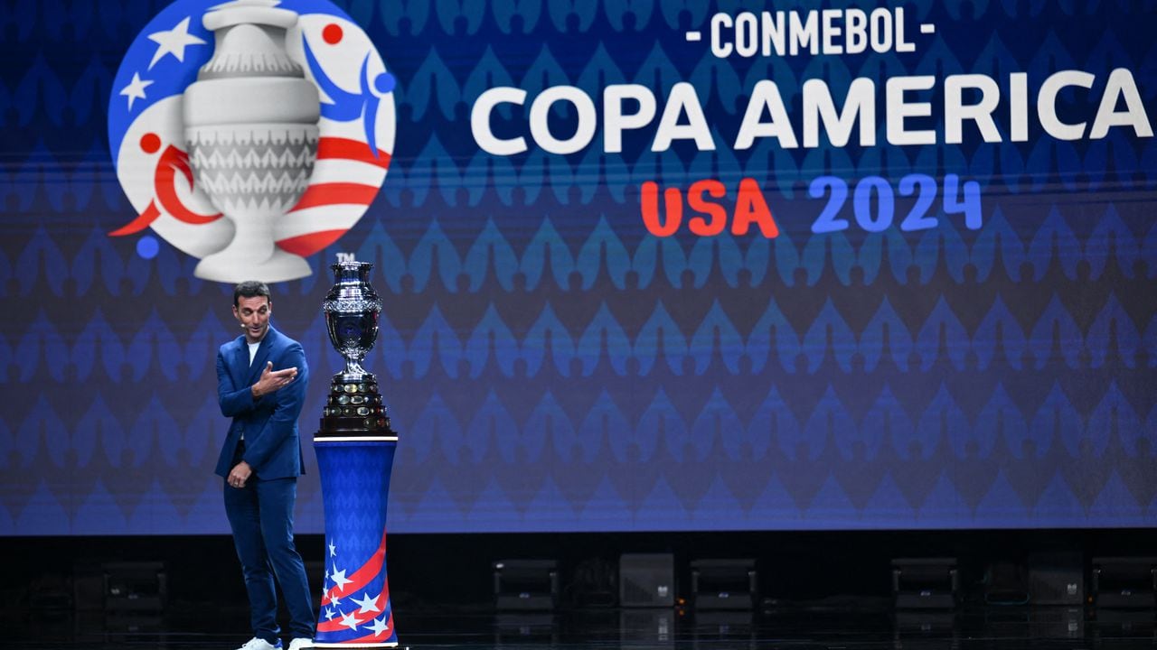 El entrenador argentino Lionel Scaloni presenta el trofeo de la Copa América en el escenario durante el sorteo final de la competición de fútbol Conmebol Copa América 2024 en el James L. Knight Center de Miami, Florida, el 7 de diciembre de 2023. (Foto de ANGELA WEISS / AFP)