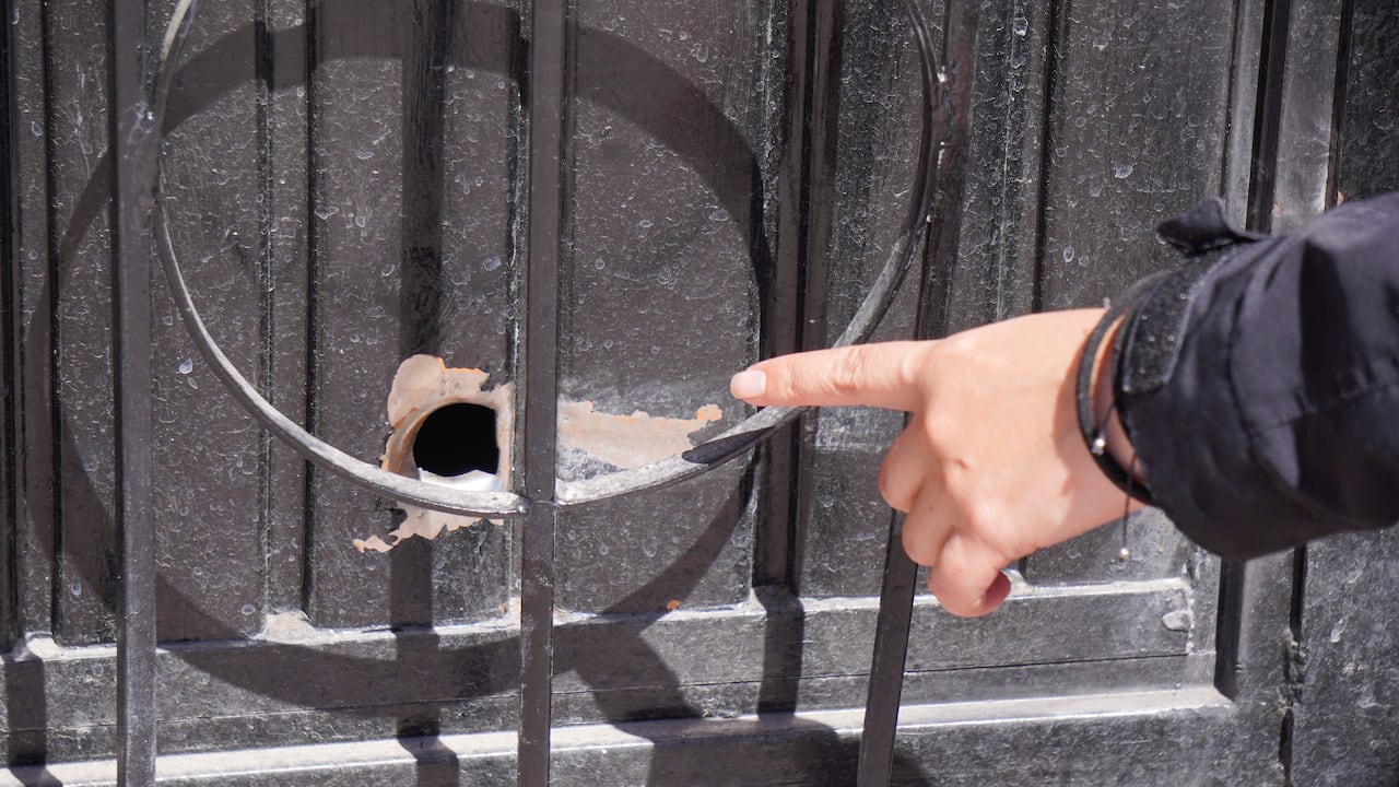 A person points at a bullet hole a day after an armed attack on a playground in San Francisco del Rincon, Guanajuato state, Mexico on February 18, 2026. An armed attack in the state of Guanajuato, in central Mexico, left a 36-year-old man dead and at least eight youths injured on a playground on February 17, 2026, another violent episode in the region that provoked terror among local neighbors. (Photo by Mario ARMAS / AFP)