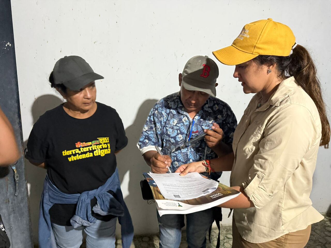 Mujeres de la Minga Cali recibiendo instrucciones sobre los predios que ahora serán de su propiedad.