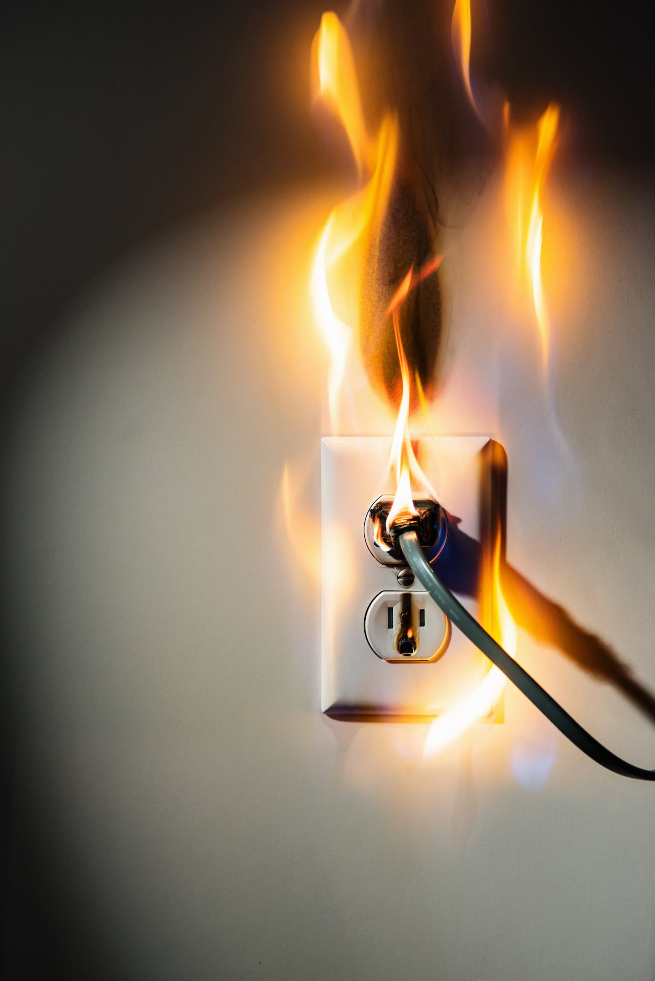 Electrical wall outlet and plug engulfed in flame