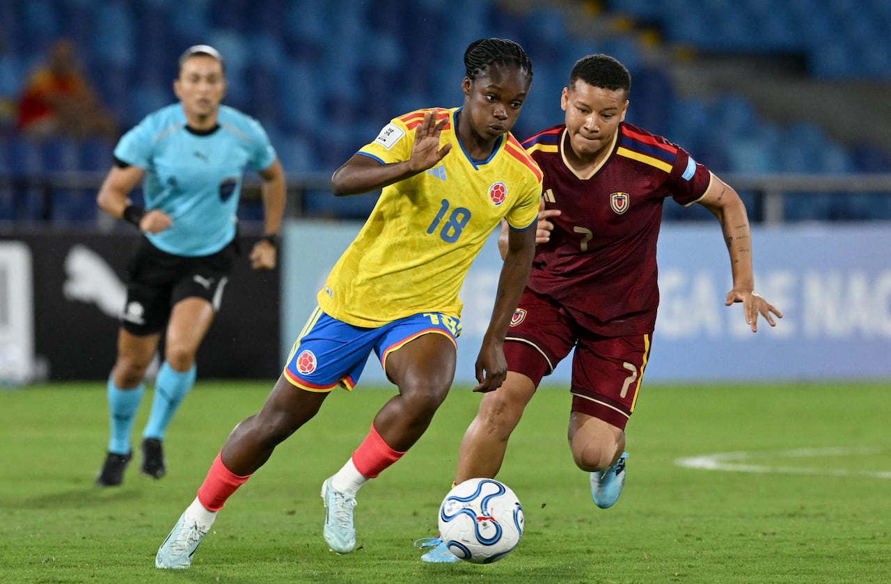 La delantera colombiana Linda Caicedo, número 18, avanza con el balón superando a la mediocampista venezolana Daniuska Rodríguez, número 7, durante el partido de la Liga de Naciones Femenina de la CONMEBOL entre Colombia y Venezuela en el estadio Olímpico Pascual Guerrero en Cali, Valle del Cauca, Colombia, el 10 de abril de 2026. (Foto de JOAQUIN SARMIENTO / AFP)