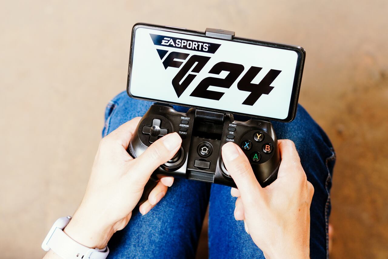 Una persona jugando con un joystick y el logotipo de EA Sports FC 24 en la pantalla de un teléfono inteligente. (Photo Illustration by Rafael Henrique/SOPA Images/LightRocket via Getty Images)