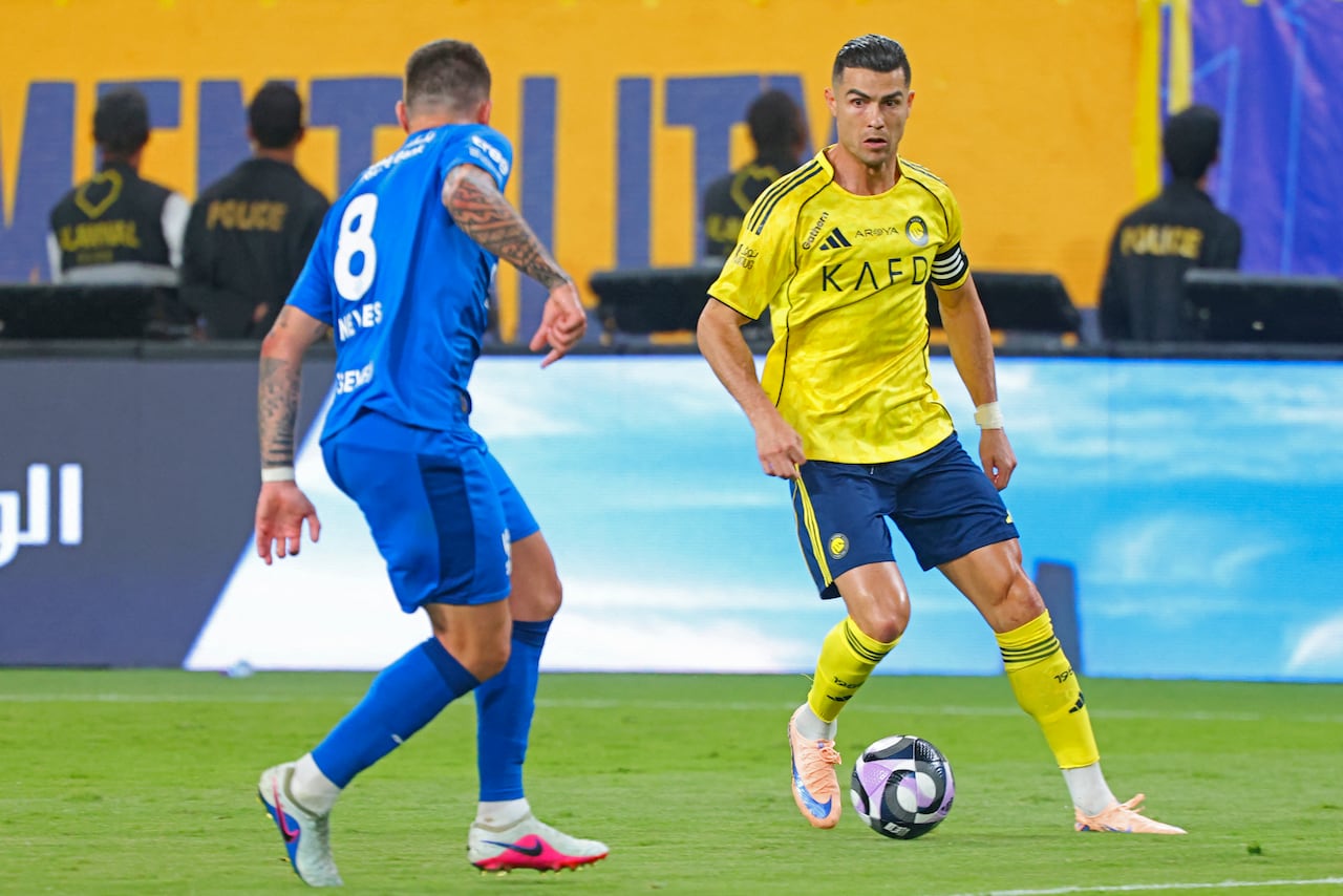 El delantero portugués del Nassr, Cristiano Ronaldo (número 07), disputa el balón con el centrocampista iraquí del Nassr, Haydeer Abdulkareem (número 08), durante el partido de la Liga Profesional Saudí entre el Al-Nassr y el Al-Hilal en el Estadio King Fahd Sports City de Riad, el 12 de mayo de 2026. (Foto de Fayez NURELDINE / AFP)