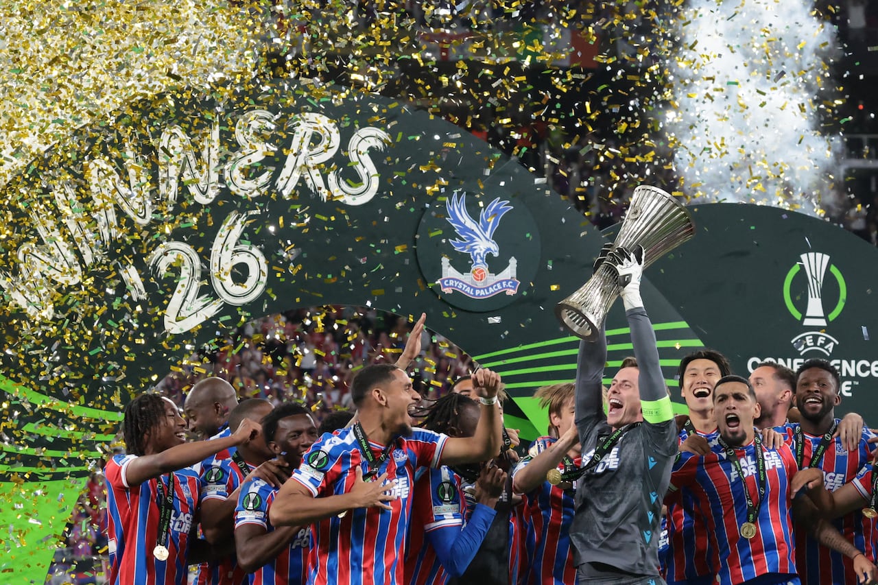 El portero inglés del Crystal Palace, Dean Henderson (C-D), levanta el trofeo mientras su equipo celebra la victoria en la final de la Liga de Conferencia de la UEFA entre el Crystal Palace FC y el Rayo Vallecano de Madrid en Leipzig, Alemania Oriental, el 27 de mayo de 2026. (Foto de Tobias SCHWARZ / AFP)