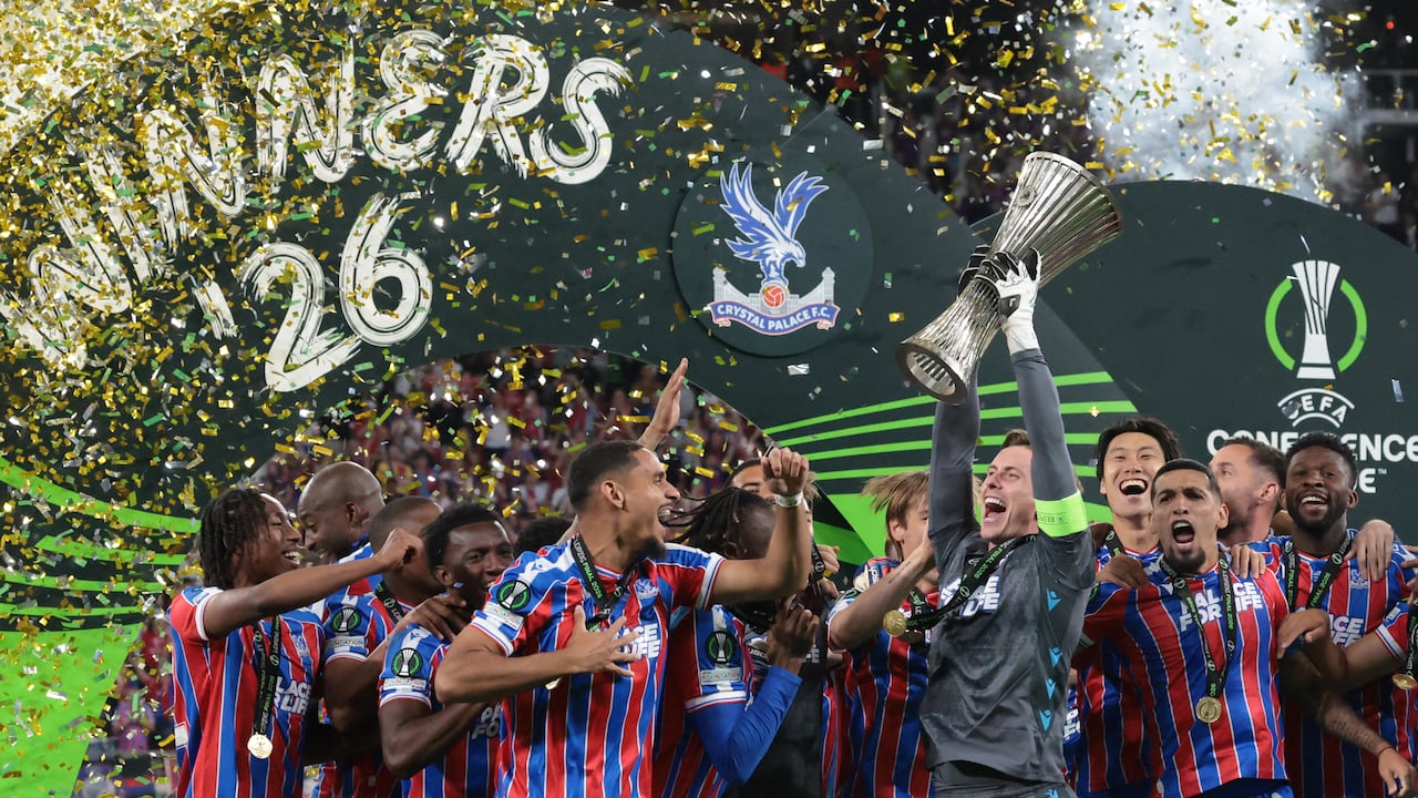 El portero inglés del Crystal Palace, Dean Henderson (C-D), levanta el trofeo mientras su equipo celebra la victoria en la final de la Liga de Conferencia de la UEFA entre el Crystal Palace FC y el Rayo Vallecano de Madrid en Leipzig, Alemania Oriental, el 27 de mayo de 2026. (Foto de Tobias SCHWARZ / AFP)