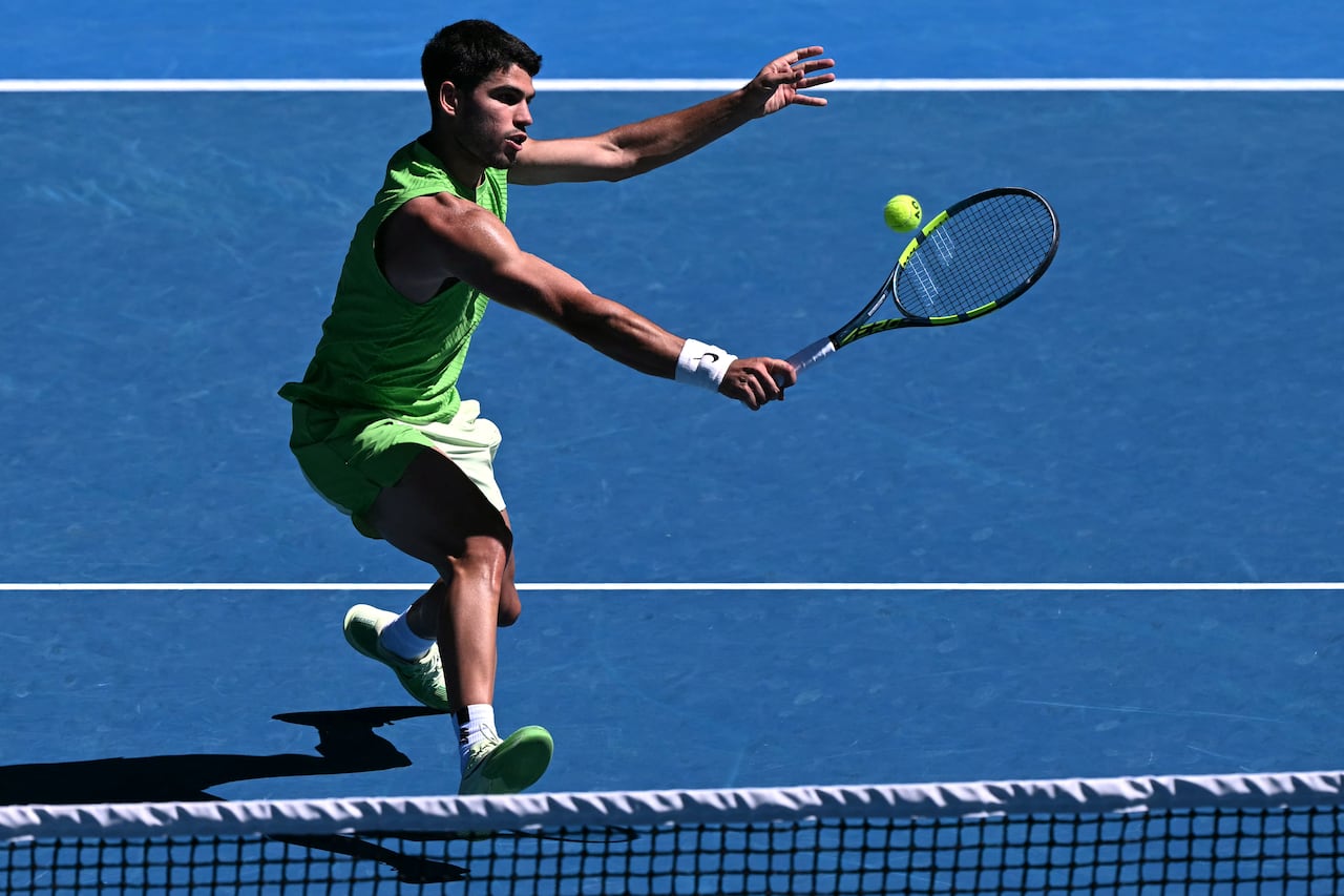 El español Carlos Alcaraz golpea contra el francés Corentin Moutet durante su partido individual masculino en el sexto día del Abierto de Australia en Melbourne el 23 de enero de 2026. (Foto de WILLIAM WEST / AFP)