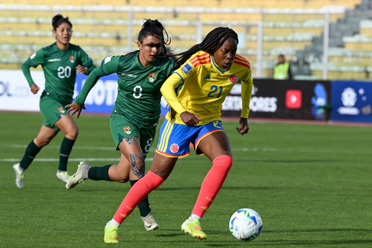 La delantera colombiana #21 Valerin Loboa corre con el balón superando a la mediocampista boliviana #08 Ruth Soliz durante el partido de fútbol de la Liga de Naciones Femenina Conmebol 2025-26 entre Bolivia y Colombia en el Estadio Hernando Siles en La Paz el 28 de noviembre de 2025. (Foto de Aizar RALDES / AFP)