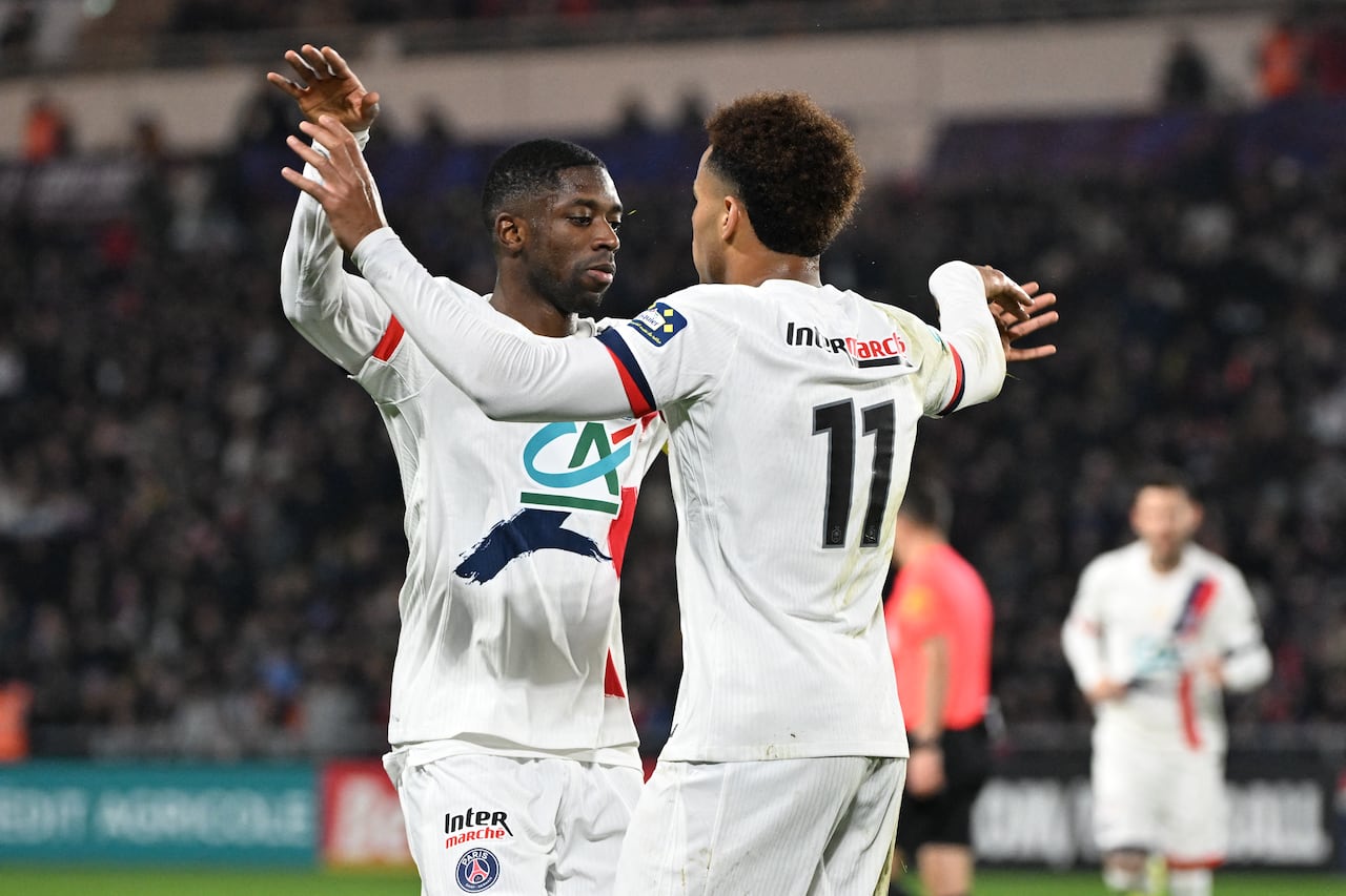 El centrocampista francés #14 del Paris Saint-Germain, Desire Doue (der.), celebra con el delantero francés #10 del Paris Saint-Germain, Ousmane Dembélé, tras anotar un gol durante el partido de octavos de final de la Copa de Francia entre Fontenay-le-Comte y el Paris Saint-Germain (PSG), en el estadio La Beaujoire, en Nantes, oeste de Francia, el 20 de diciembre de 2025. (Foto de Sebastien Salom-Gomis / AFP)