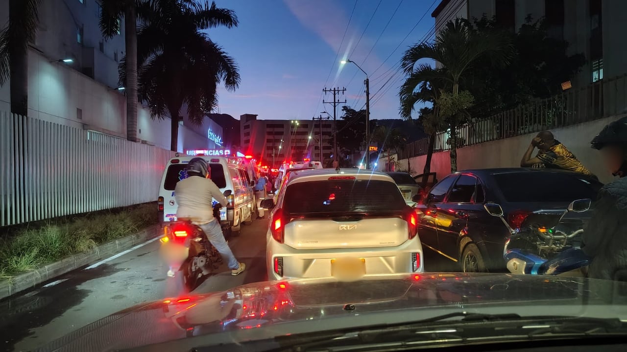 Ambulancias estacionadas en doble fila, vehículos particulares y ventas ambulantes ocupando la Avenida 3 N, frente a la Clínica Cali, donde residentes reportan congestión constante durante todo el día.