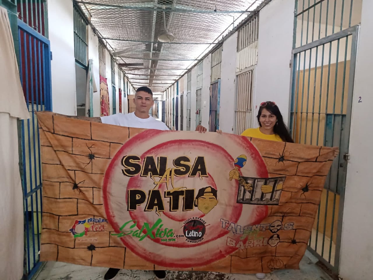 Sebastián Montaño y Stefhania Agudelo López, trabajadora social, con el trapo que reconoce a ‘Salsa al patio’ dentro de los pasillos de Villahermosa.