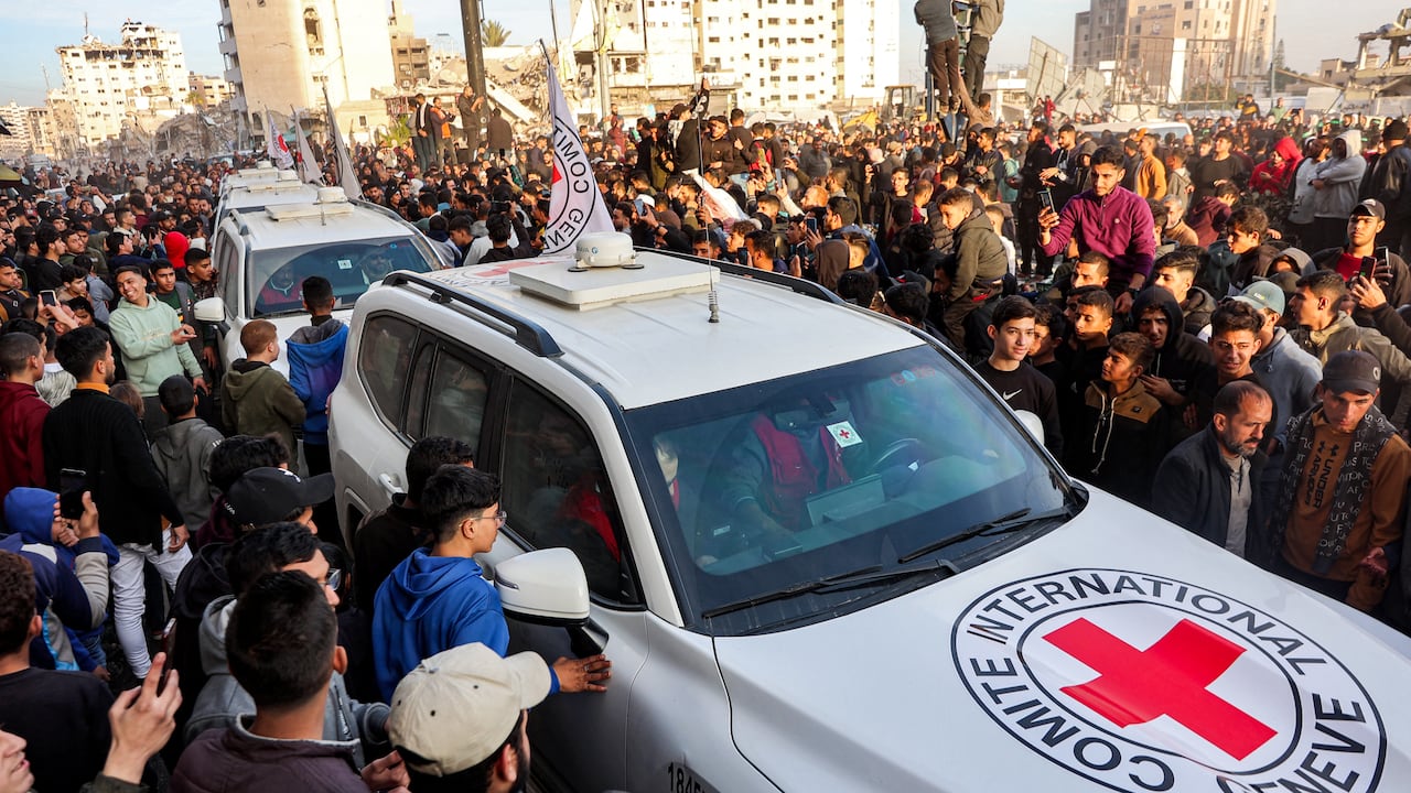 La gente se reúne alrededor de un vehículo del Comité Internacional de la Cruz Roja (CICR) en la plaza Saraya, en el oeste de la ciudad de Gaza, el 19 de enero de 2025. El ejército israelí dijo que la Cruz Roja había confirmado la entrega de tres rehenes el 19 de enero