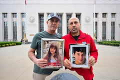 Los padres del Reino Unido, Mariano Janin y George Nicolaou, sostienen fotos de sus hijos frente al Tribunal Superior del Condado de Los Ángeles, el 9 de febrero de 2026.