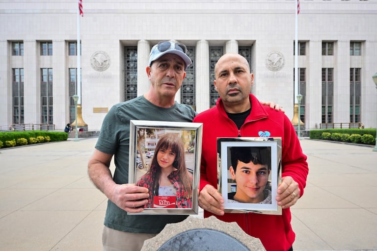 Los padres del Reino Unido, Mariano Janin y George Nicolaou, sostienen fotos de sus hijos frente al Tribunal Superior del Condado de Los Ángeles, el 9 de febrero de 2026.