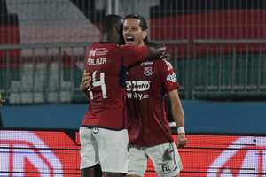 Independiente Medellin's Uruguayan forward Joaquin Varela (R) celebrates after scoring with teammate midfielder Baldomero Perlaza during the Copa Sudamericana round of 16 first leg football match between Chile's Palestino and Colombia's Independiente Medellin at the National stadium in Santiago, on August 14, 2024. (Photo by Rodrigo ARANGUA / AFP)