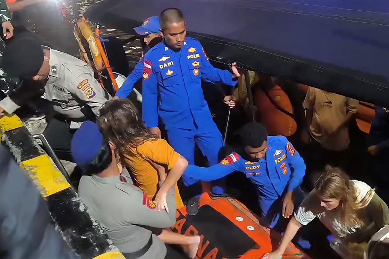 Esta fotografía, tomada y difundida el 27 de diciembre de 2025 por la Agencia Nacional de Búsqueda y Rescate de Labuan Bajo (BASARNAS Labuan Bajo), muestra a miembros de los equipos de búsqueda y rescate evacuando a turistas extranjeros en aguas de la isla de Padar, en Labuan Bajo, Nusa Tenggara Oriental, después de que un barco turístico sufriera una falla en el motor y se hundiera. Una familia española de cuatro miembros se encuentra desaparecida tras el naufragio de un barco turístico en Indonesia, informó la agencia estatal de noticias Antara el 27 de diciembre. El barco transportaba 11 personas cuando se hundió en el estrecho de la isla de Padar, cerca del popular destino turístico de Labuan Bajo, el viernes por la noche, según Antara. (Foto de Handout / BASARNAS / AFP) / USO EDITORIAL RESTRINGIDO - CRÉDITO