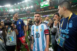 El delantero argentino Lionel Messi se marcha de la cancha tras una riña entre hinchas, previa al partido de la eliminatoria mundialista ante Brasil en el Maracaná, el martes 21 de noviembre de 2023. (AP Foto/Silvia Izquierdo)