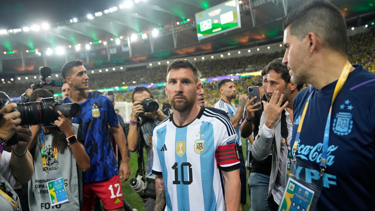 El delantero argentino Lionel Messi se marcha de la cancha tras una riña entre hinchas, previa al partido de la eliminatoria mundialista ante Brasil en el Maracaná, el martes 21 de noviembre de 2023. (AP Foto/Silvia Izquierdo)