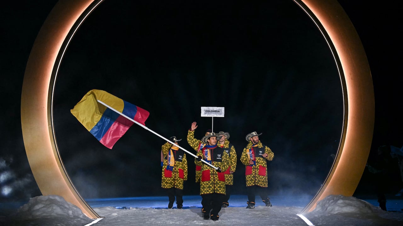 El abanderado colombiano, Fredrik Fodstad, desfila durante la ceremonia de apertura de los Juegos Olímpicos de Invierno Milano Cortina 2026 en el Estadio de Salto de Esquí de Predazzo (Val di Fiemme), el 6 de febrero de 2026. (Foto: Javier SORIANO / AFP)