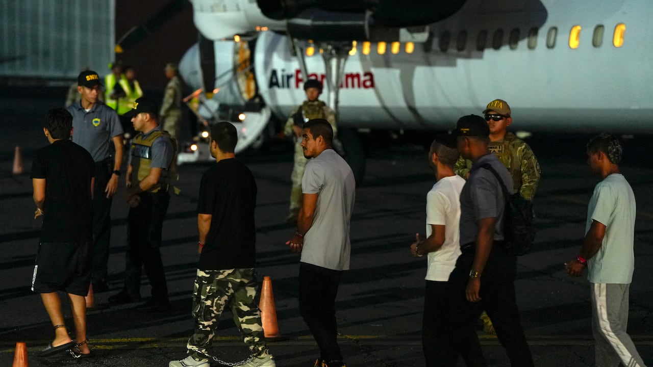 Migrantes colombianos, con las manos y los pies esposados, hacen fila para subir a un avión en el aeropuerto de Albrook Gelabert en la ciudad de Panamá el 20 de agosto de 2024, durante su deportación. Panamá deportó este martes a 29 colombianos con antecedentes penales que habían ingresado al país a través del inhóspito Tapón del Darién, aplicando por primera vez un acuerdo sobre repatriaciones de migrantes firmado con Estados Unidos en julio. (Foto de ARNULFO FRANCO / AFP)