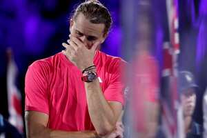 El alemán Alexander Zverev se derrumba, con lágrimas, después de perder el partido final individual masculino, contra el italiano Jannik Sinner (Photo by Martin KEEP / AFP)