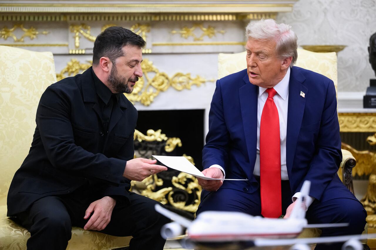 El presidente ucraniano, Volodímir Zelenski, entrega una carta de su esposa al presidente estadounidense, Donald Trump, durante una reunión en la Oficina Oval de la Casa Blanca en Washington.