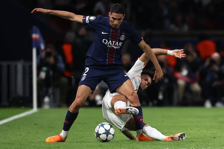 El delantero colombiano del Bayern de Múnich, Luis Díaz (D), número 14, disputa el balón con el defensa marroquí del Paris Saint-Germain, Achraf Hakimi (D2), durante el partido de la jornada 4 de la fase de grupos de la UEFA Champions League entre el Paris Saint-Germain (PSG) y el FC Bayern de Múnich en el Parque de los Príncipes de París, el 4 de noviembre de 2025. (Foto de Anne-Christine Poujoulat / AFP)