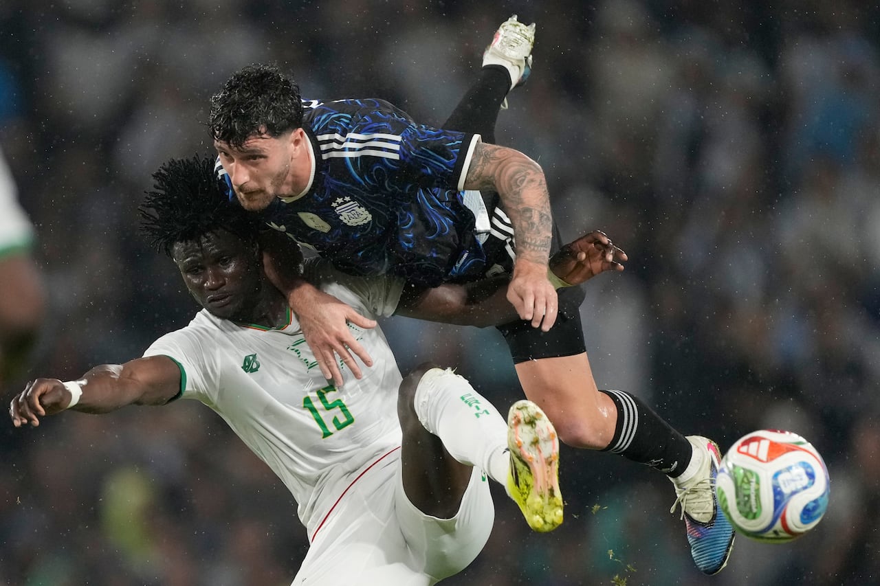 Marcos Senesi, de Argentina, y Pape Ndiaga Yade, de Mauritania, luchan por el balón durante un partido amistoso de fútbol en Buenos Aires, Argentina.