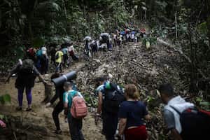 En esta imagen de archivo, migrantes cruzan a pie la selva del Darién desde Colombia a Panamá, con la esperanza de llegar a Estados Unidos, el 9 de mayo de 2023. El aumento de migrantes que van desde Colombia a Estados Unidos, a través de la selva del Darién hasta Panamá, alcanza una escala industrial que podría rondar las 500.000 personas este año. (AP Foto/Iván Valencia, archivo)
