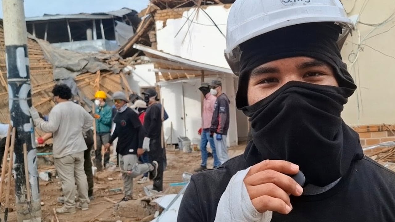 Un joven con casco y tapabocas se abre paso entre los escombros de una vivienda afectada por el sismo en Roldanillo.