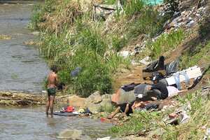 El Río Cali a la altura del Boulevard y la Calle 34 con Avenida 2 Norte se puede notar la contaminación por basuras y personas bañándose en este afluente.