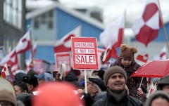 Personas ondean banderas groenlandesas durante una manifestación que reunió a casi un tercio de la población de la ciudad para protestar contra los planes del presidente estadounidense de apropiarse de Groenlandia, el 17 de enero de 2026 en Nuuk, Groenlandia.