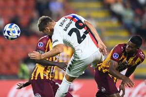 El delantero de Tigre Tomas Badolani (C) salta para un cabezazo durante el partido de ida de la fase de grupos de la Copa Suramericana entre Deportes Tolima y Tigre.