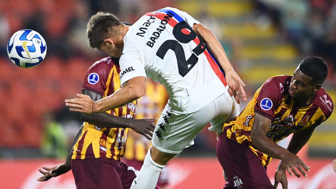 El delantero de Tigre Tomas Badolani (C) salta para un cabezazo durante el partido de ida de la fase de grupos de la Copa Suramericana entre Deportes Tolima y Tigre.
