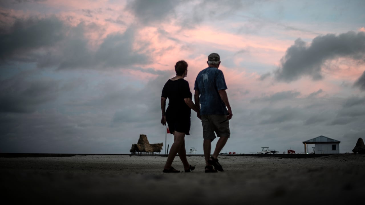Una pareja camina por la playa de Cayo Ambergris, en el norte de Belice.