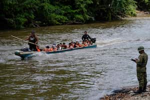 Migrantes llegan a Lajas Blancas, en donde los espera un agente de la policía fronteriza de Panamá a la orilla del río Chucunaque, en la provincia de Darién, el viernes 6 de octubre de 2023, en Panamá. (AP Foto/Arnulfo Franco)
