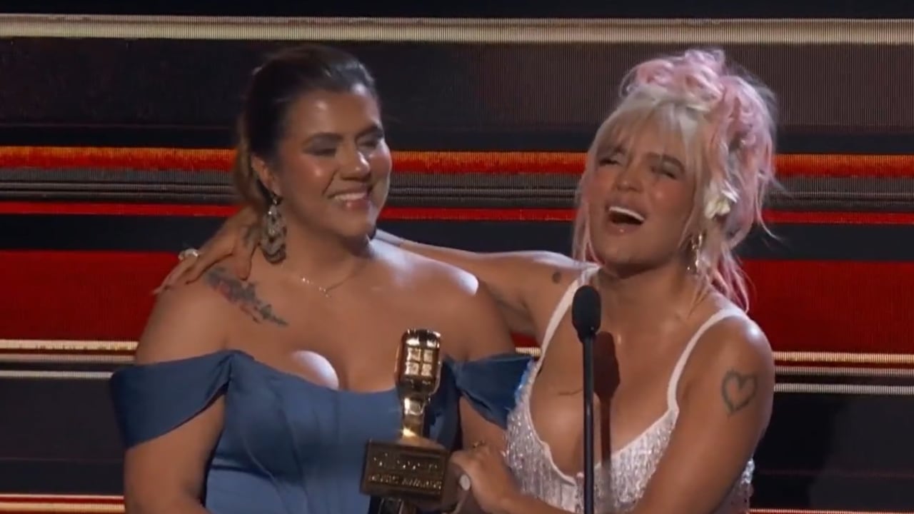 Momento en el que Karol G le cede su Premio Billboard a la directora de su fundación Con Cora.