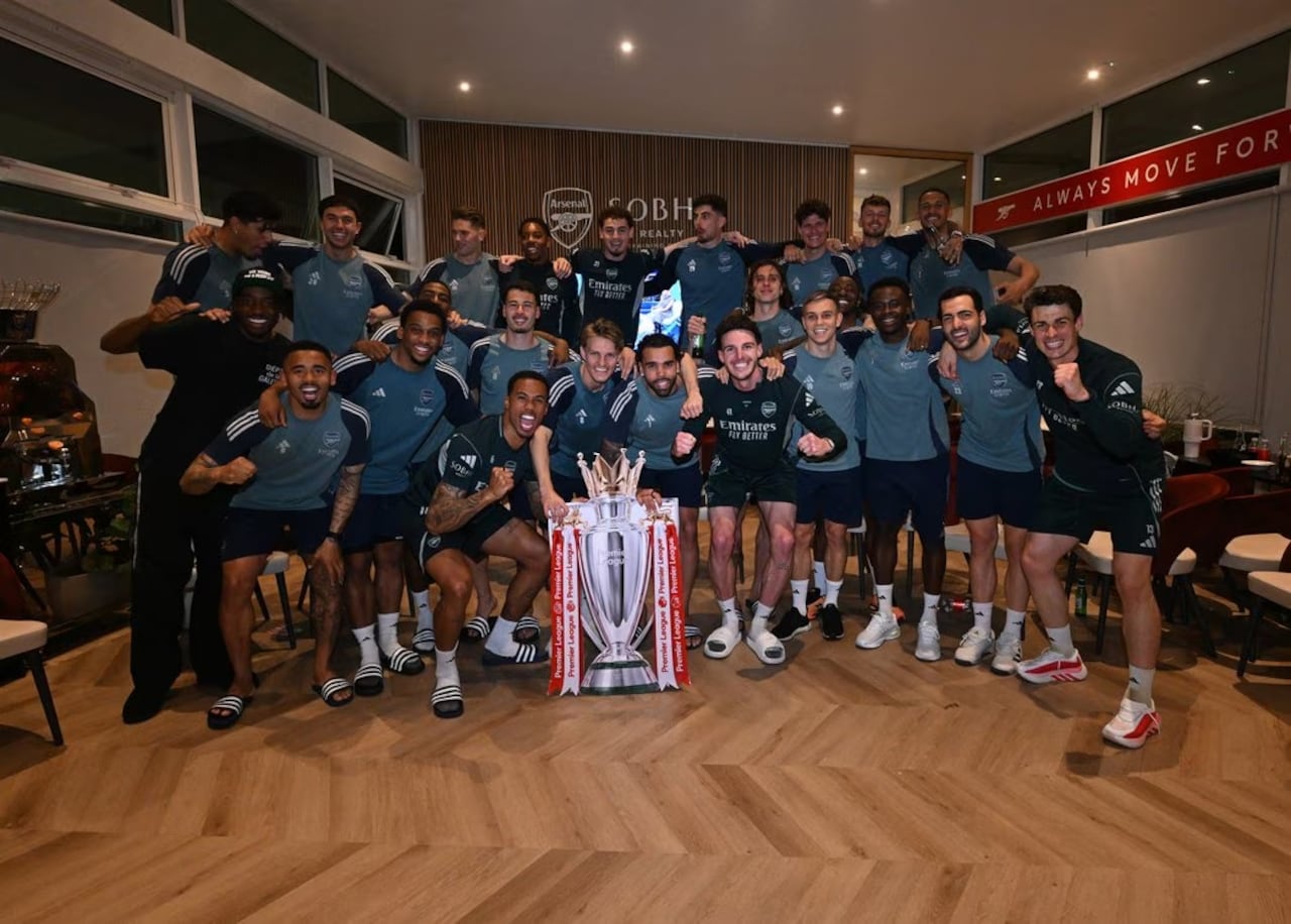 Jugadores del Arsenal celebran el título de la Premier League con una imagen del trofeo que recibirá el próximo fin de semana.